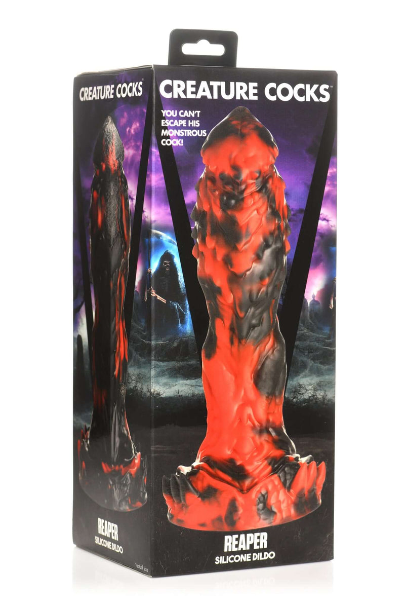 Creature Cocks Reaper Silicone Dildo in packaging against a dark, ominous background