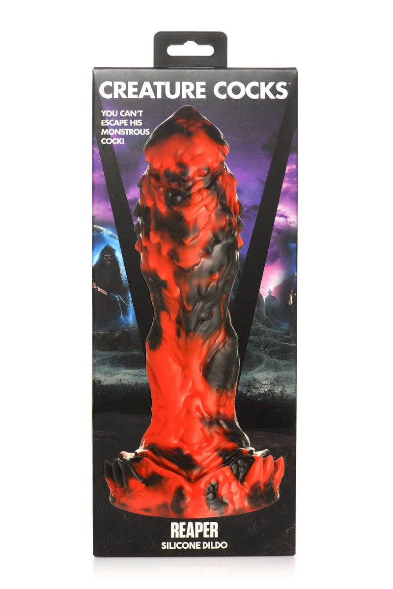 Red and black Creature Cocks Reaper Silicone Dildo with textured surface in packaging against purple and black background.