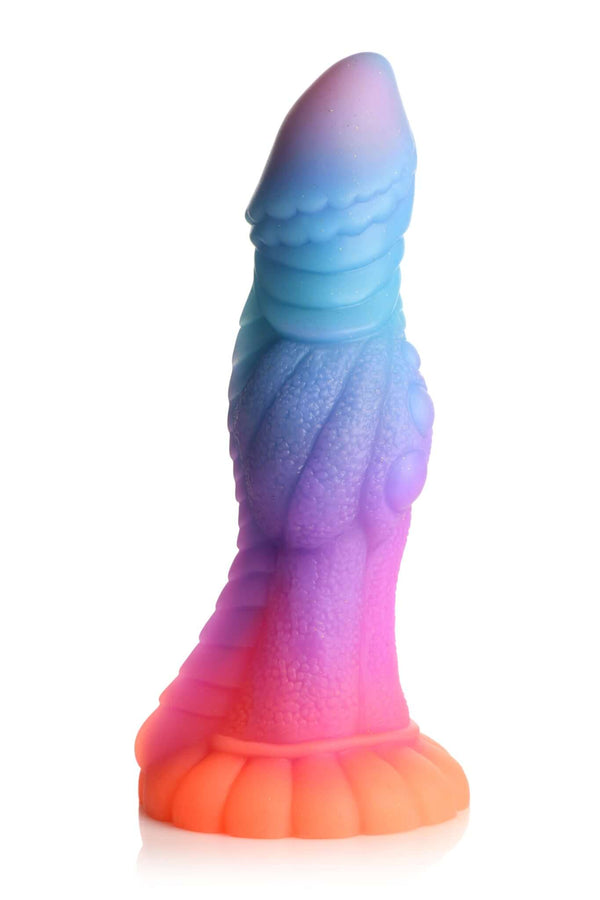 Glow-in-the-dark Galactic Cock alien dildo by XR Brands in vibrant pink, orange, blue, and purple colors with glitter accents.