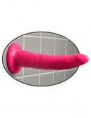 Pink Dillio 7" slim dildo with suction cup base attached to a tiled wall surface.
